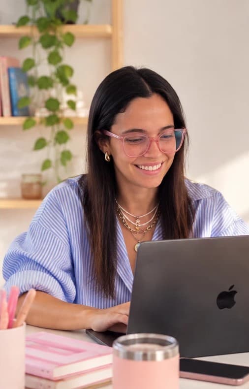 Juli trabajando en su computadora, sonriendo